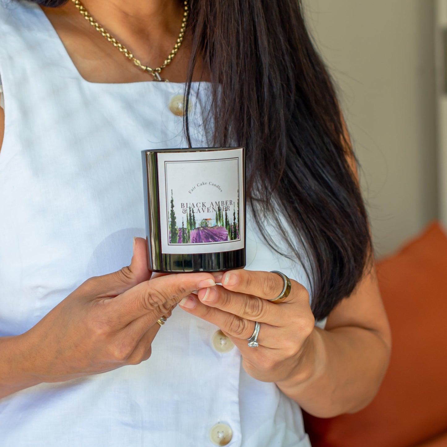 Person holding a black amber and lavender candle by Fair Cake Candles