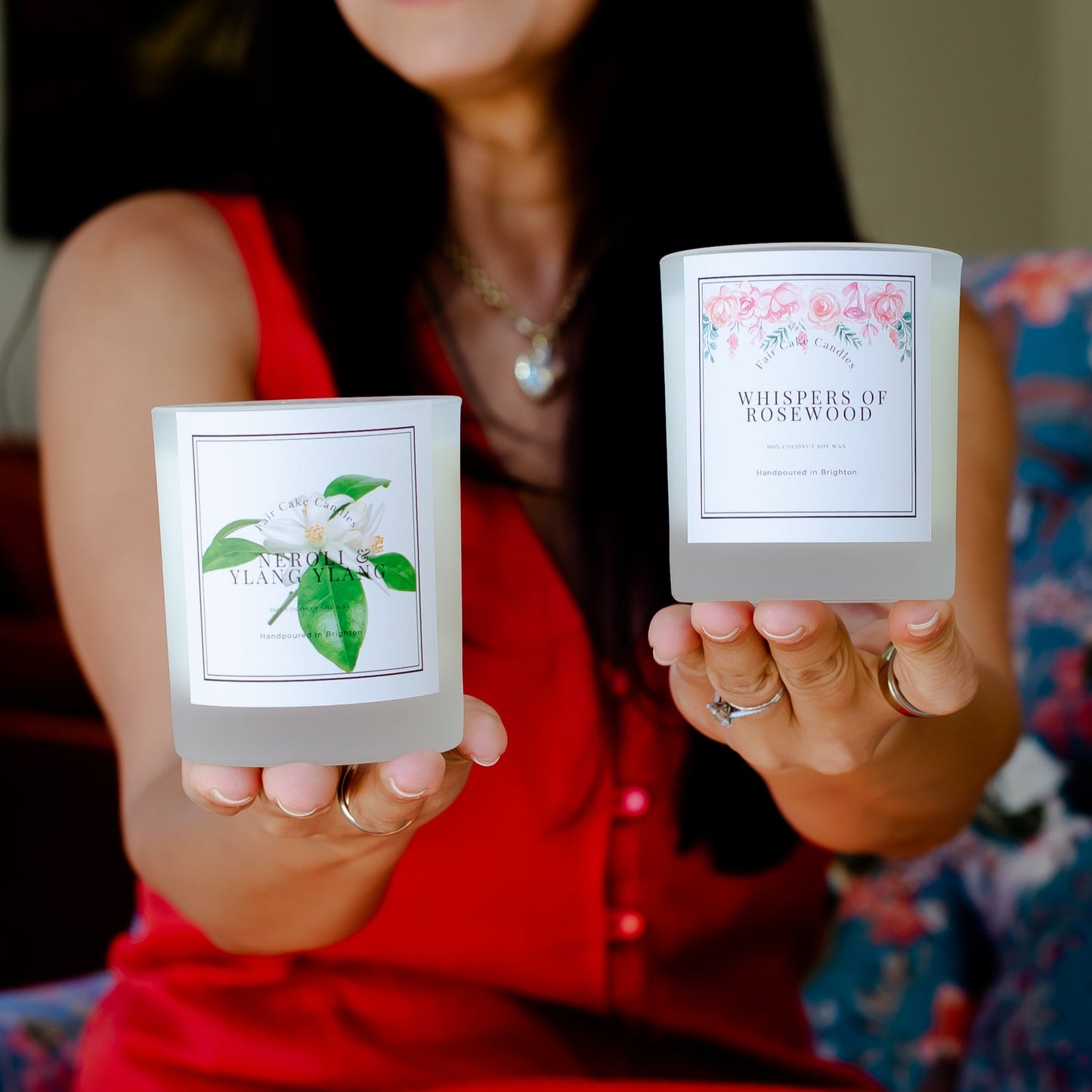 Woman holding two candles: Neroli and Ylang Ylang and Whispers of Rosewood