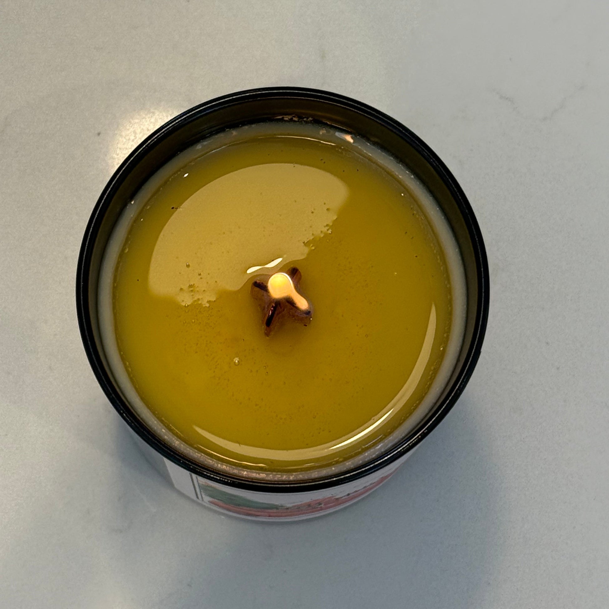 Candle in a glass jar with a wick on a light grey background