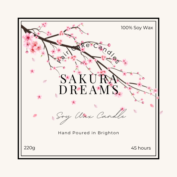 Label of a Sakura Dreams soy wax candle, depicting a branch of cherry blossoms and product details such as weight and burn time.