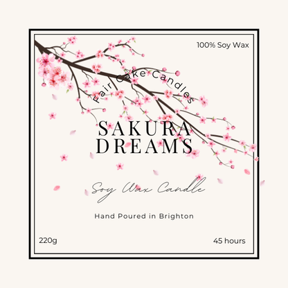 Label of a Sakura Dreams soy wax candle, depicting a branch of cherry blossoms and product details such as weight and burn time.