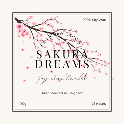 Label of a Sakura Dreams soy wax candle, depicting a branch of cherry blossoms and product details such as weight and burn time.